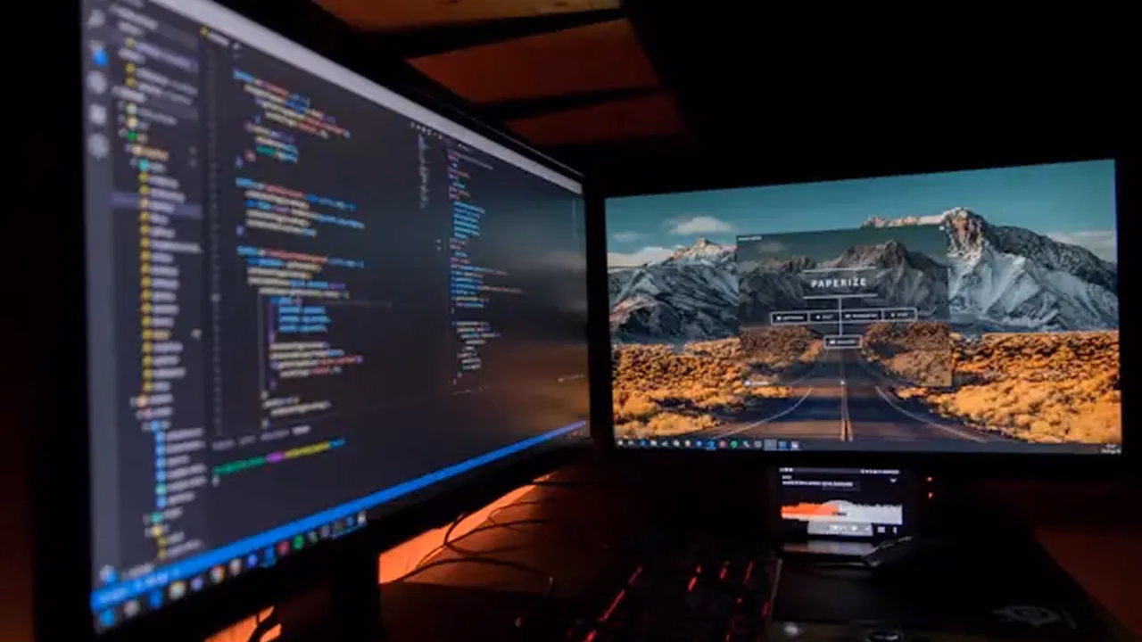 Code spread across two monitors at a developer desk, as used by concurrent Go programs