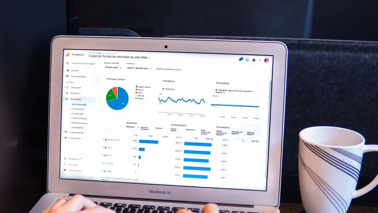 MacBook showing a Google Analytics dashboard with traffic and acquisition charts